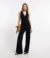Blusa estilo chaleco color marrón, confeccionada en ribana, con abotonado delantero, sin mangas y con textura acanalada.