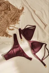 Conjunto de bikini blanco con textura, compuesto por un corpiño de triángulo fijo con breteles regulables y almohadillas desmontables, y una bombacha vedetina con frunce elástico en los costados.