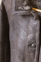 Tapado marrón de cuero gamuzado con cuello y puños de piel sintética.