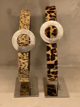 Cinto de cuero con estampado animal print y hebilla circular plateada.