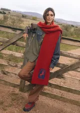 Bufanda larga tejida a mano color ladrillo, con parche bordado de un caballo y la frase "The Ranch Dress Code".