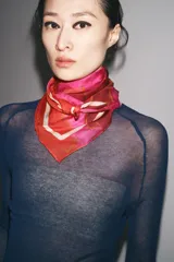 Pañuelo cuadrado de modal y seda con estampado de amapolas en tonos rojos y fucsias, y borde blanco.