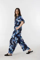 Pantalón culotte de lino azul marino con estampado de flores azules y blancas, tiro alto, cintura con tablas, bolsillos laterales y cierre frontal.