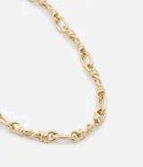 Collar corto dorado con eslabones ovalados y eslabones con palitos torcidos rígidos.