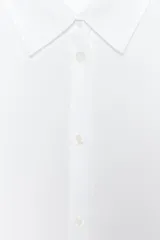 Camisa blanca de lyocell con cuello solapa, manga larga y bajo asimétrico. Cierre frontal con botones.