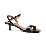 Sandalias negras de charol con tira delgada sobre los dedos y tobillo con hebilla dorada.