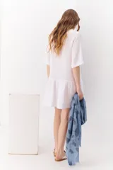 Vestido blanco de lino con cuello mao, manga corta y corte evasé.