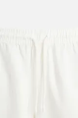 Bermuda negra regular fit confeccionada en tejido de algodón con estructura. Cintura elástica ajustable con cordón, bolsillos laterales y bolsillo trasero de vivo.