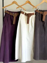 Falda midi de micro pana color morado oscuro, de corte recto y cintura elastizada. Incluye un cinturón desmontable de cuero marrón.