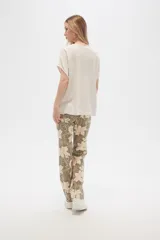 Pantalón de lino color verde oliva con estampado de flores color crema, de corte recto.