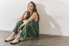 Sandalias de cuero color crema con tira ancha sobre los dedos, suela plana cuadrada color negro y tira trasera ajustable.