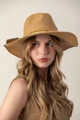 Sombrero de paja color beige con ala ancha, detalle de cuentas de madera y adorno de flecos y plumas azules.