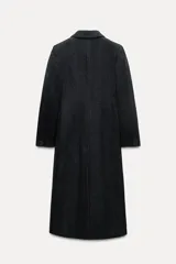 Abrigo largo de Zara Woman Collection confeccionado en tejido con 30% lana. Tiene cuello solapa de muescas, manga larga con abertura y botones, bolsillos con solapa en el delantero y de vivo en el pecho. Forro interior a tono y cierre frontal cruzado con botones.