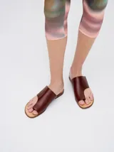 Sandalias de cuero color marrón con tira ancha sobre el empeine y abertura para el dedo gordo.