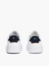 Zapatillas de corte bajo confeccionadas en una mezcla de piel y poliuretano, de color blanco con un panel a contraste en el talón. Presentan cierre de cordones, suela de goma y el logo de Tommy Hilfiger en el lateral.
