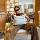 Bandolera color marrón claro, con dos bolsillos frontales paralelos con cierre, apertura superior con doble cierre y divisiones independientes, bolsillos internos y bolsillo trasero con cierre. Incluye correa larga regulable.