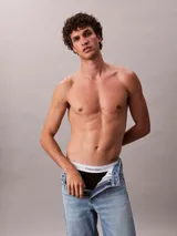 Pack de tres slips negros de algodón con cintura elástica blanca con el logo de Calvin Klein.