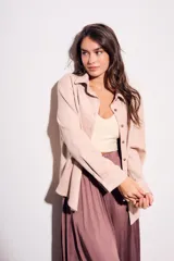 Camisa color marrón de gamuza sintética, de corte recto, con cuello clásico, cierre frontal con botones y mangas largas.