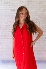 Camisola roja tipo vestido camisero, de corte midi, con cuello camisero, abotonada al frente y con abertura en el ruedo.