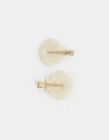 Set de dos hebillas para el pelo con forma de caracola esmaltada color crema y broche metálico dorado.