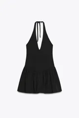Minivestido negro con escote halter, espalda descubierta y falda con volantes.
