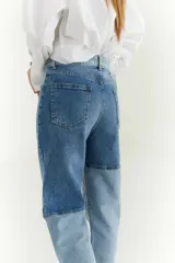 Pantalón de jean con diseño patchwork en diferentes tonos de azul, corte recto y tiro alto.
