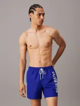 Short de baño azul con cintura elastizada y cordón blanco. Logo de Calvin Klein estampado en blanco en la pierna izquierda.
