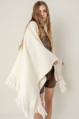 Ruana de punto color negro, modelo Esteña, con diseño abierto y terminación de flecos en los bordes.