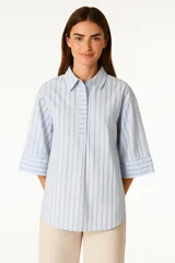 Camisa celeste a rayas verticales, de corte holgado y manga 3/4.