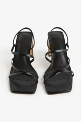 Sandalias negras de taco grueso con tiras finas en el empeine y tira elástica en el talón.