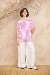 Camisa amplia de manga corta con rayas verticales celestes y blancas, con cuello clásico y terminaciones en rojo.