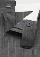 Pantalón gris con finas rayas verticales blancas, de corte wide leg, con trabillas, pinzas y bolsillos laterales.