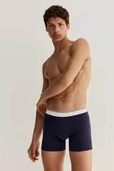 Pack de tres calzoncillos tipo trunk en punto elástico de algodón, color gris, blanco y azul marino, con cintura elástica blanca con una fina línea negra. Confeccionados con la tecnología Lycra® Xtra Life™.