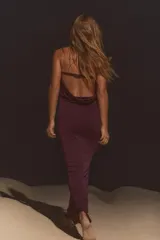 Vestido largo de color borgoña, de escote recto y hombros descubiertos. Escote drapeado en espalda con tira ajustable con ganchos metálicos.