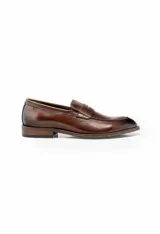 Mocasín de cuero color marrón claro, con antifaz y suela de cuero.