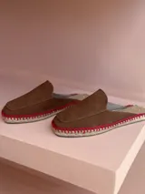 Zuecos color chocolate de gamuza con suela de yute y costuras rojas.