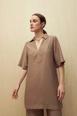 Vestido corto negro de línea relajada con cuello tipo solapa y escote en V profundo, mangas cortas amplias y calce suelto.