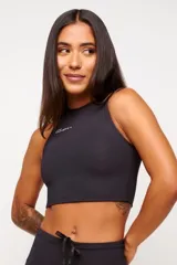 Top deportivo blanco de corte cropped, con cuello alto y logo estampado en el frente.