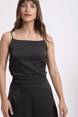 Crop top negro de satén con breteles finos regulables y corte holgado.