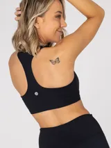 Top deportivo negro con espalda racerback y soporte medio. Cuenta con almohadillas removibles y sujetador integrado.
