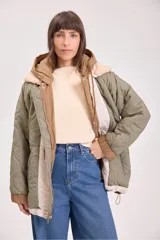Campera acolchada reversible color verde militar, con capucha y cierre frontal con botones a presión.