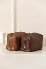 Necessaire de cuero vacuno color marrón, con cierre superior y bolsillo interno. Ideal para artículos de tocador.
