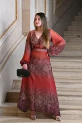 Vestido largo de gasa con estampado animal print en tonos marrones y rojizos. Tiene escote en V, mangas largas abullonadas y corte en la cintura.