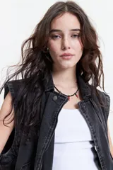 Chaleco denim negro con fit relajado y hombros caídos.