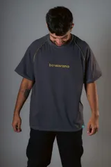 Remera gris de manga raglán con costuras a la vista y calce relajado. Estampado frontal con la palabra "bowwana" en amarillo.