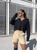 Short color beige de ecocuero con cinturón con hebilla plateada.