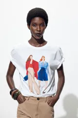 Camiseta blanca de algodón con estampado de dos figuras femeninas.