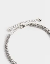 Collar corto plateado con múltiples cadenas y dijes colgantes: rosas, corazón y moño.