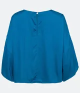 Blusa celeste de viscosa con textura satinada, cuello redondo, manga corta con sisa desplazada y abertura en la espalda.