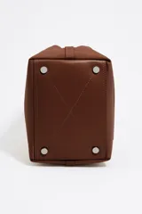 Bolso tote pequeño marca Bimba y Lola, modelo Chihuahua, color marrón. Confeccionado en nylon con estructura blanda, doble asa de mano y asa de tejido, piezas de piel, cierre con botón de presión, logo grabado, acabados metálicos, bolsillo interior e interior con placa metálica logotipada.